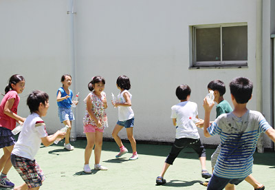 暑いので休憩の時に水を掛け合って遊ぶ児童たち