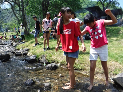 小川で水遊びをする女の子たち