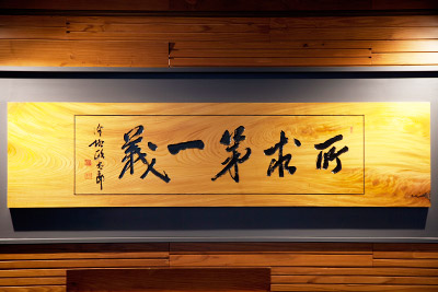 長野県産のケヤキ一枚板に彫り込んだ澤柳直筆の書「所求第一義」をロビーに掲げています。