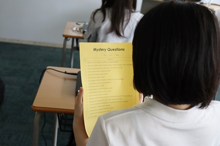 始める前に相手に投げかける質問「Mystery Questions」を確認する生徒たち