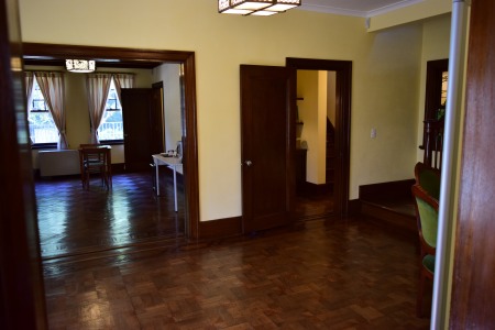 玄関側から見た食堂（左奥が居間）。寄木の床が印象的