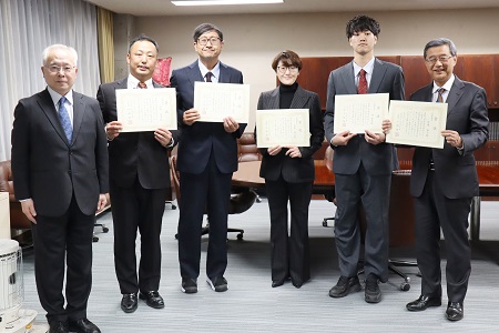 戸部学園長（左）と渡辺初等学校校長（右）と理科部のメンバー（※1名欠席）