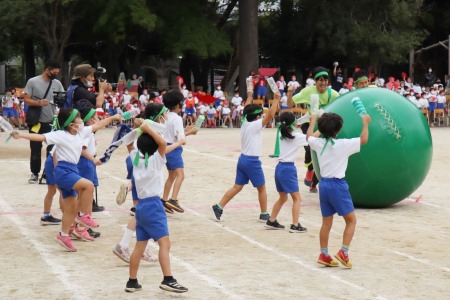 教職員の大玉ころがし。「先生がんばれ！！」同じチームの先生たちに大きな声援を贈る子どもたち