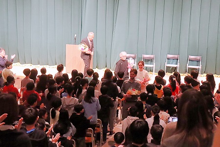 全員の合唱で見送られながら会場をあとにする教職員たち