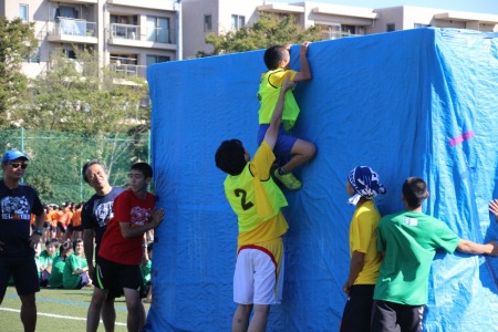 大学生が小学生を抱え上げて障壁を越える！