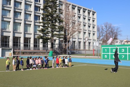 「手を高くあげると高く飛ぶよ」先生のアドバイスを聞いて凧揚げにチャレンジする年少さん