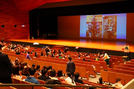 幼稚園のホールの様子を投影。天井まで届くクリスマスツリーに、子どもたちが飾りつけをしました