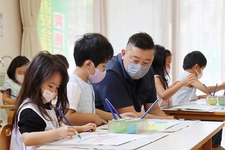 「とってもいい感じ！」夢中で描いている子どもたち一人一人に智力先生が声をかけてくれます