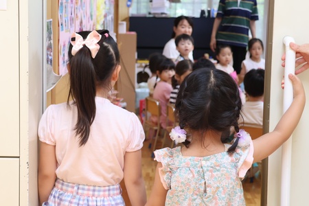 「お店やさん、開店します。来てください！」年中組、年少組の部屋を訪ねて声かけする年長組の園児